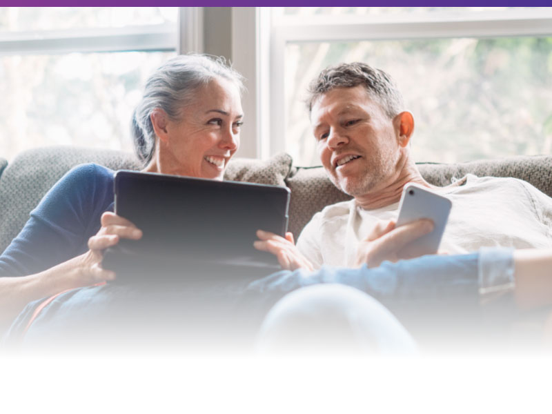 couple on couch using wireless devices