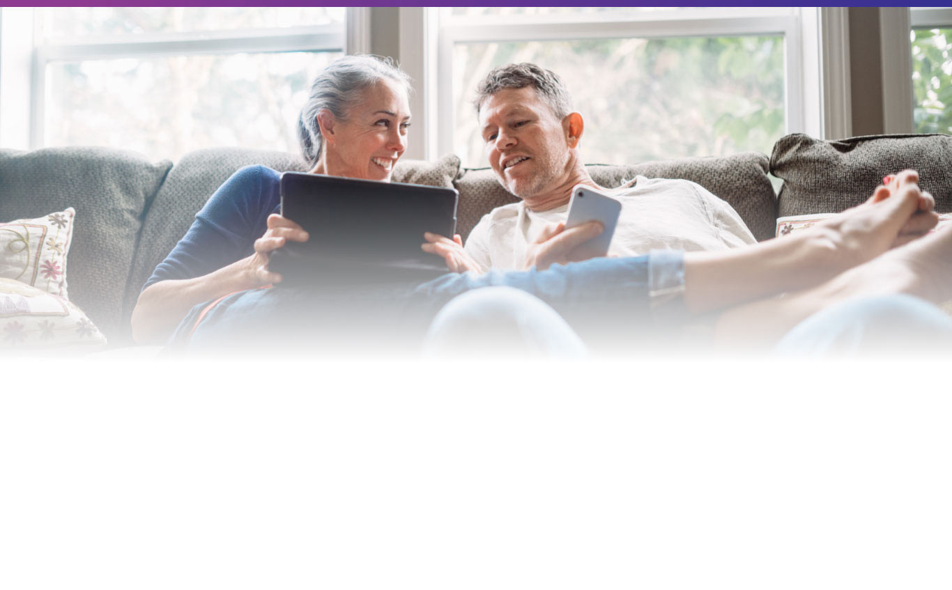 couple on couch using wireless devices