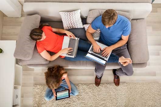 Three family members with laptops.