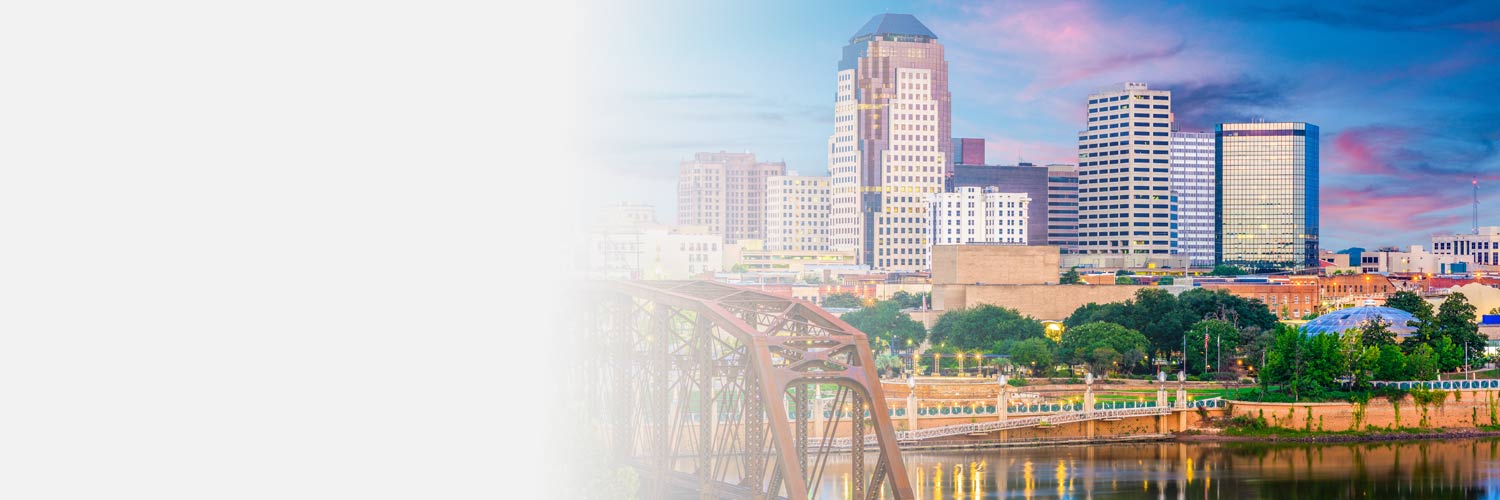 A view of the city of Shreveport, LA including a glimpse of a lake and bridge