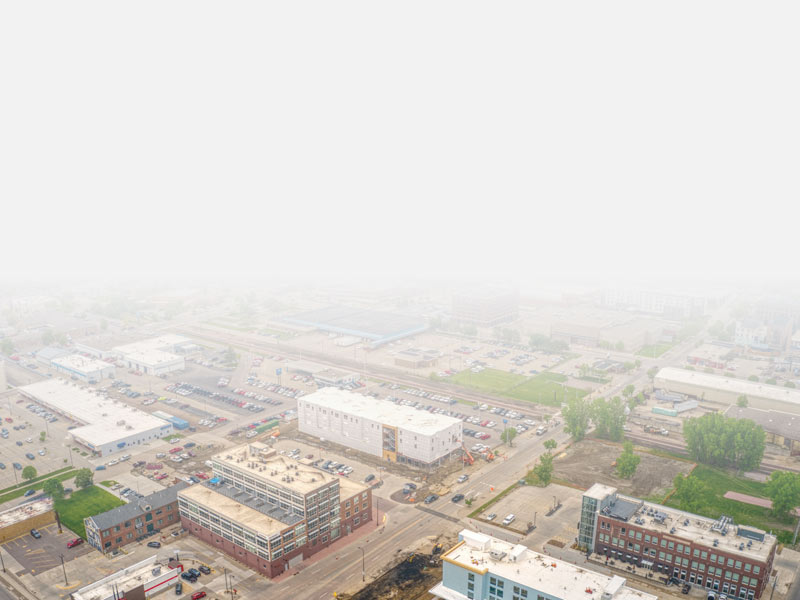 A sky view of Sioux City, IA that shows buildings, trees, streets, and cars