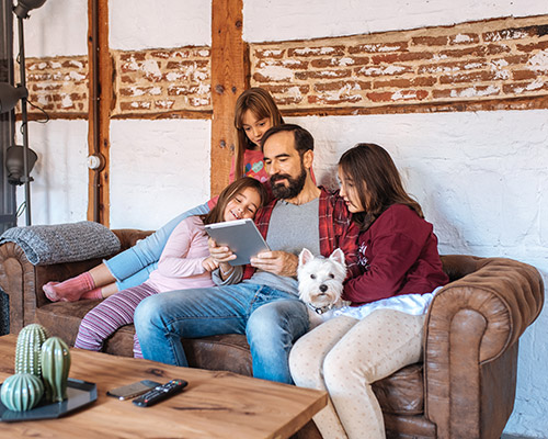 a family is enjoying a video call on their tablet with their relative from out of state 