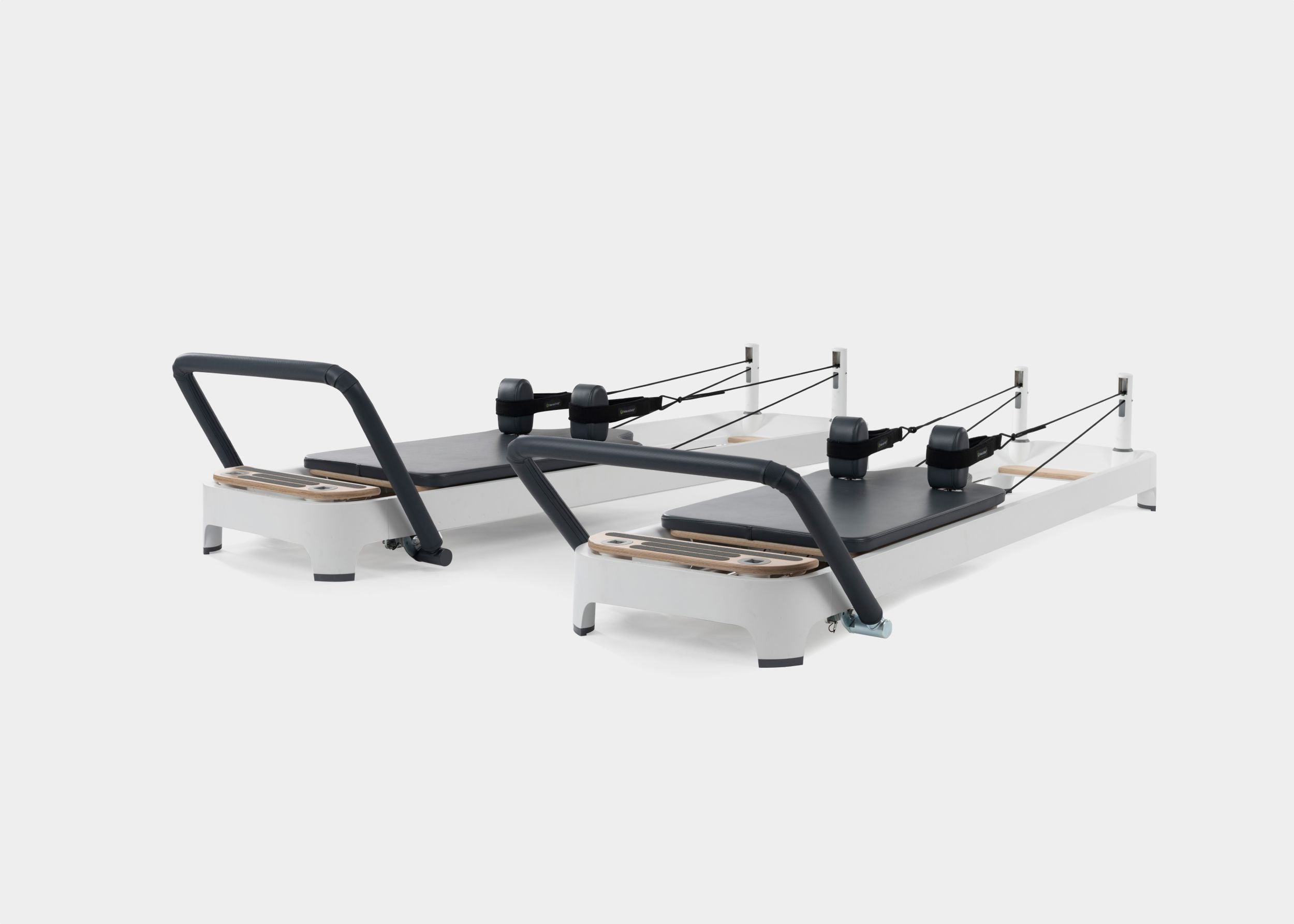 A photo of the Allegro 2 Pilates Reformer showing both the carbon fiber footbar and the steel footbar options. 