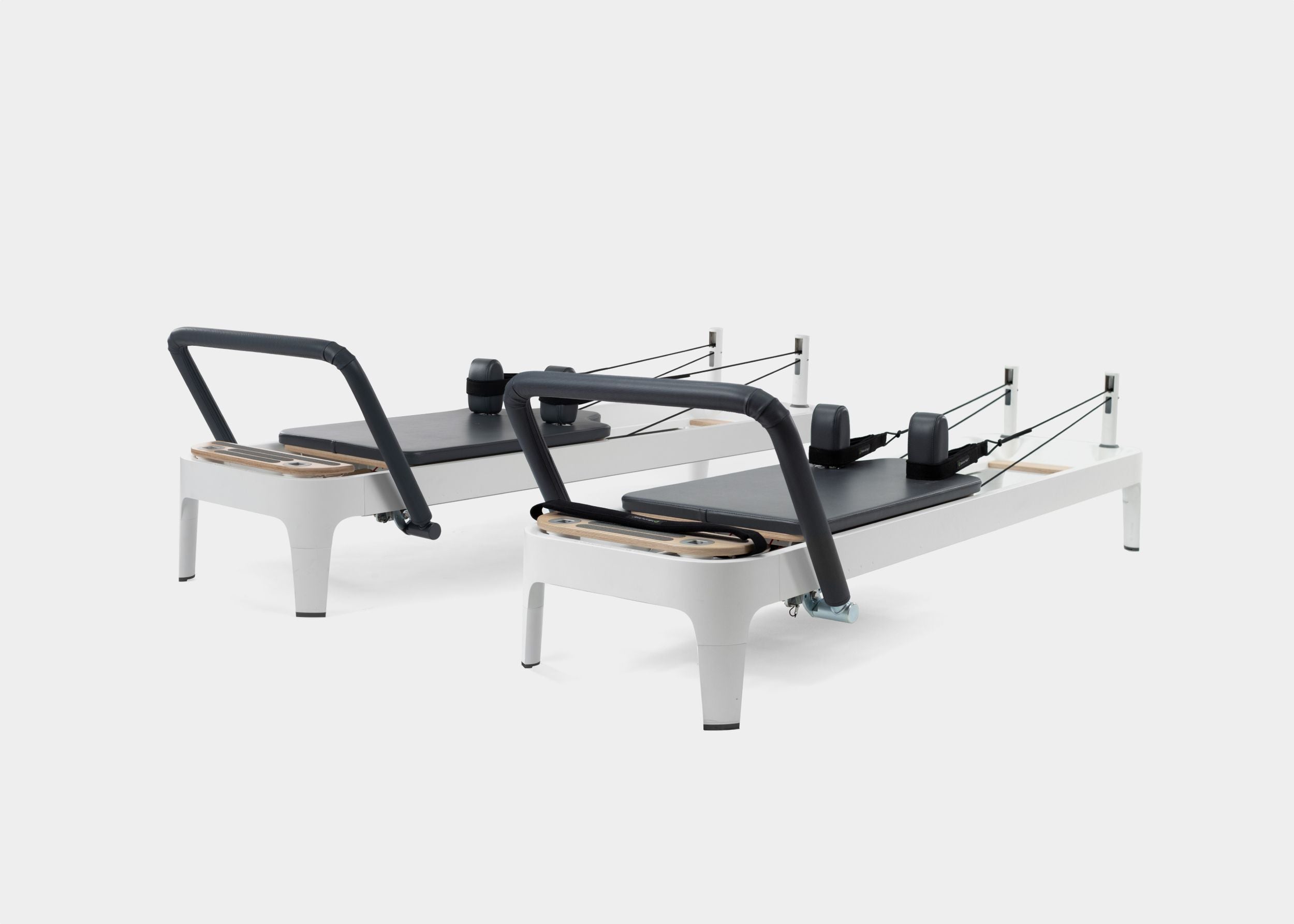 A photo of the Allegro 2 Pilates Reformer with legs showing both the carbon fiber footbar and the steel footbar options. 