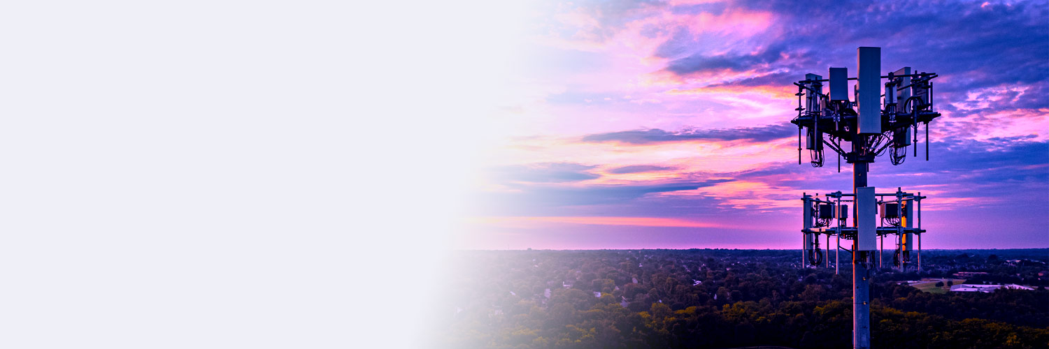 A cellular tower is shown along with a beautiful purple, cloudy sky