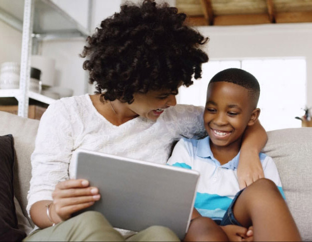 smiling parent and child playing on tablet